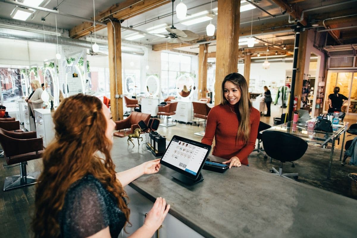 Deux personnes en interaction chaleureuse dans un commerce local, illustrant la relation client positive